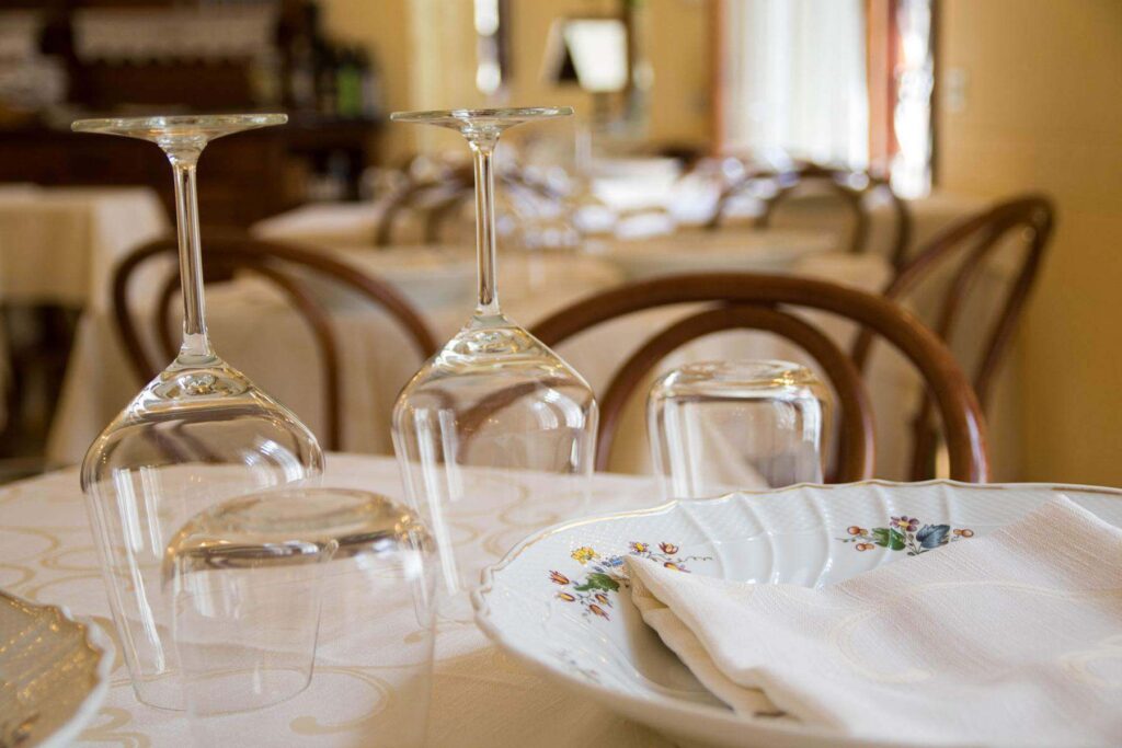 Foto ristorante Viareggio – calici e piatto apparecchiati al tavolo